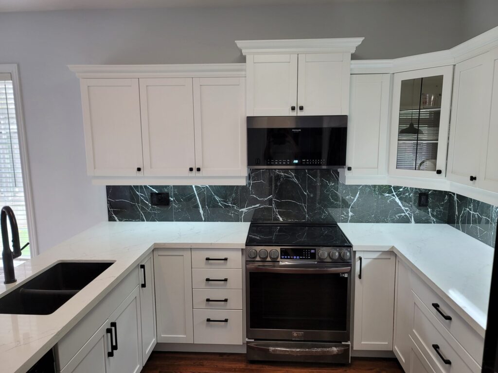White kitchen with dark marble backsplash and stainless steel range