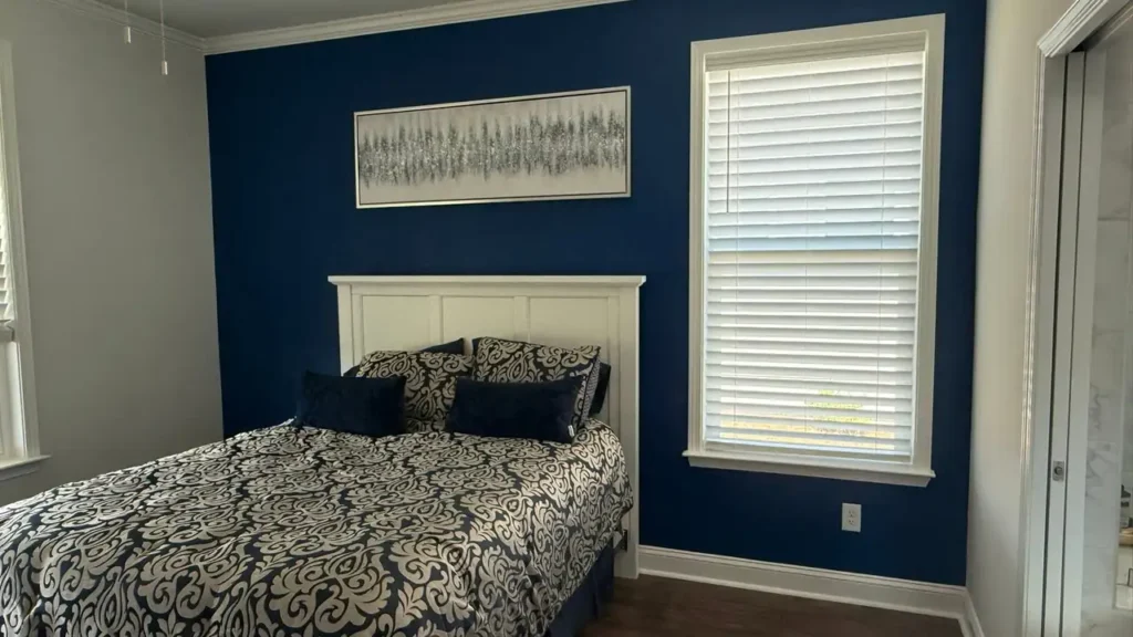 Bedroom with a navy blue accent wall and white trim