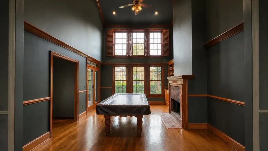 Game room with dark gray walls, wood trim and a pool table