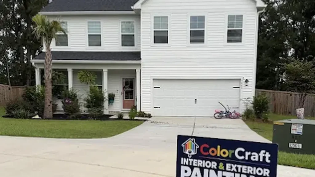 Two-story white house with a ColorCraft Painters yard sign