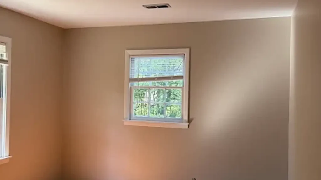Room with freshly painted beige walls and white window trim