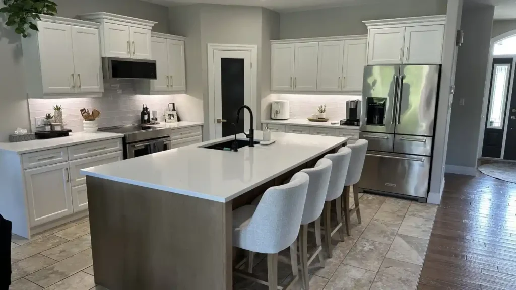 Kitchen with white painted cabinets and a gray island